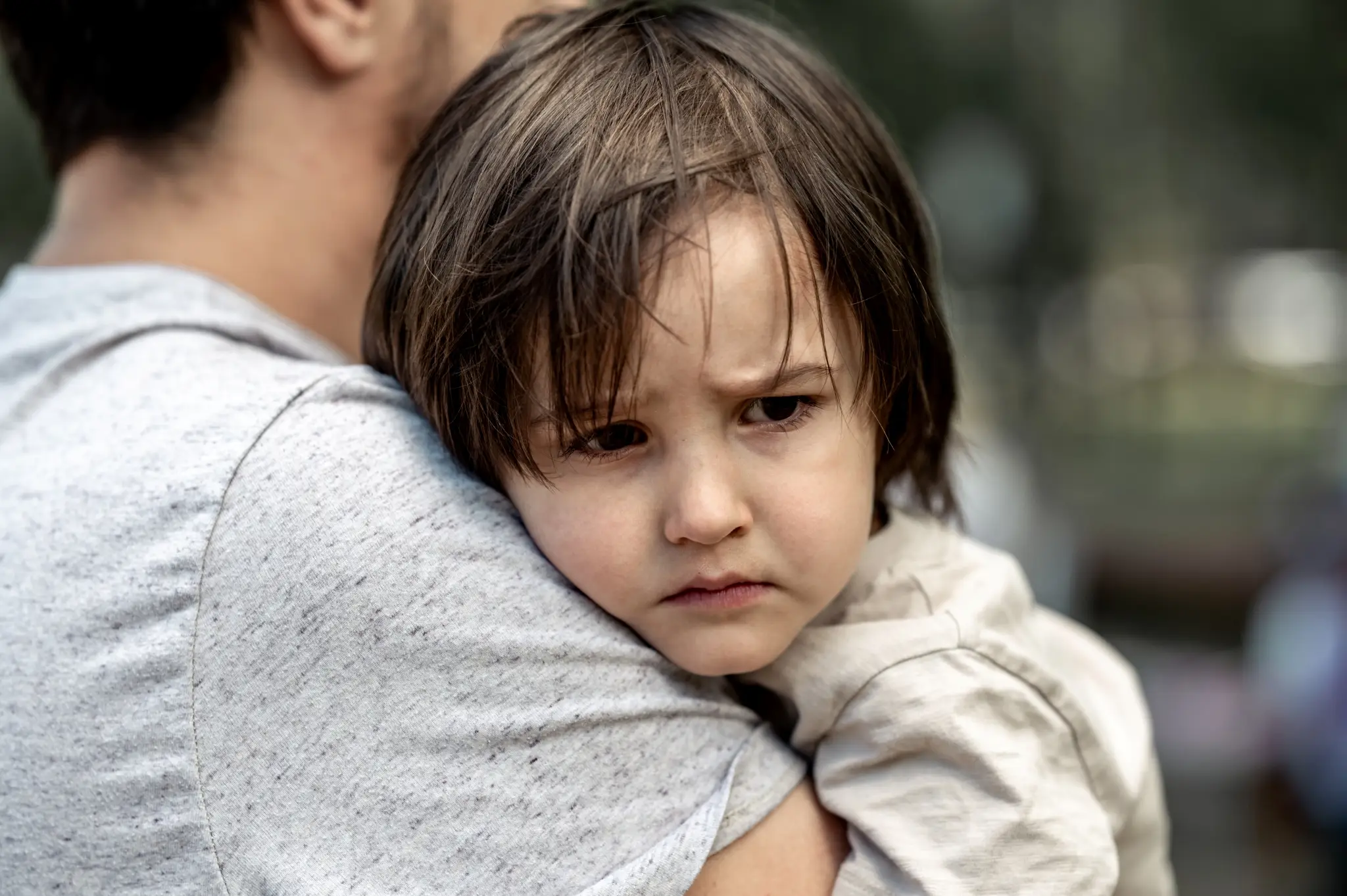 Jeune enfant dans les bras d’un adulte